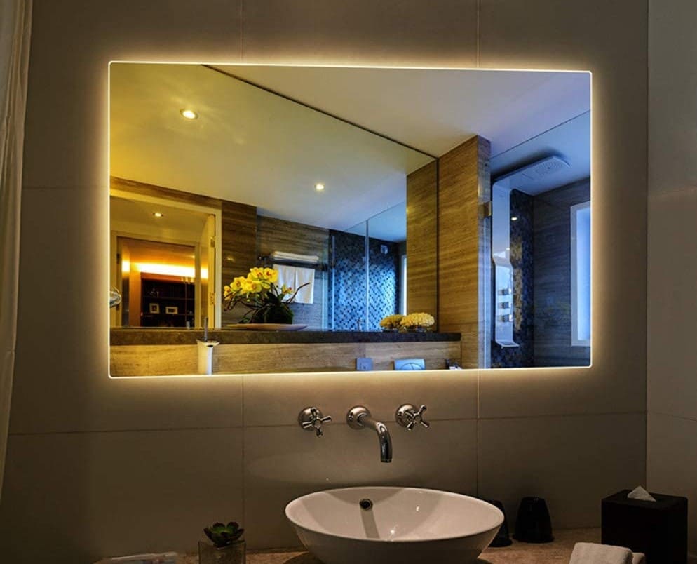 Illumintad bathroom mirror with countertop washbasin and wall mounted basin tap