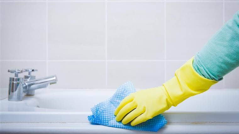 hand scrubbing the mould away in a bathtub
