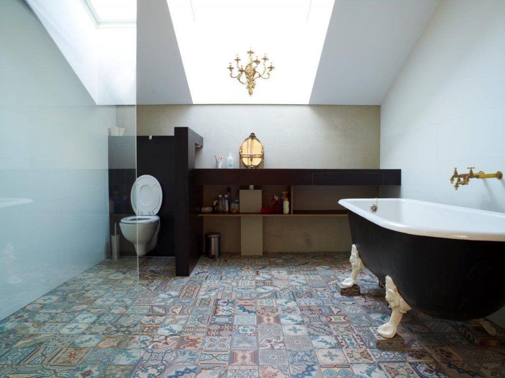 Portuguese bathroom floor tiles in combination with a black bath tub